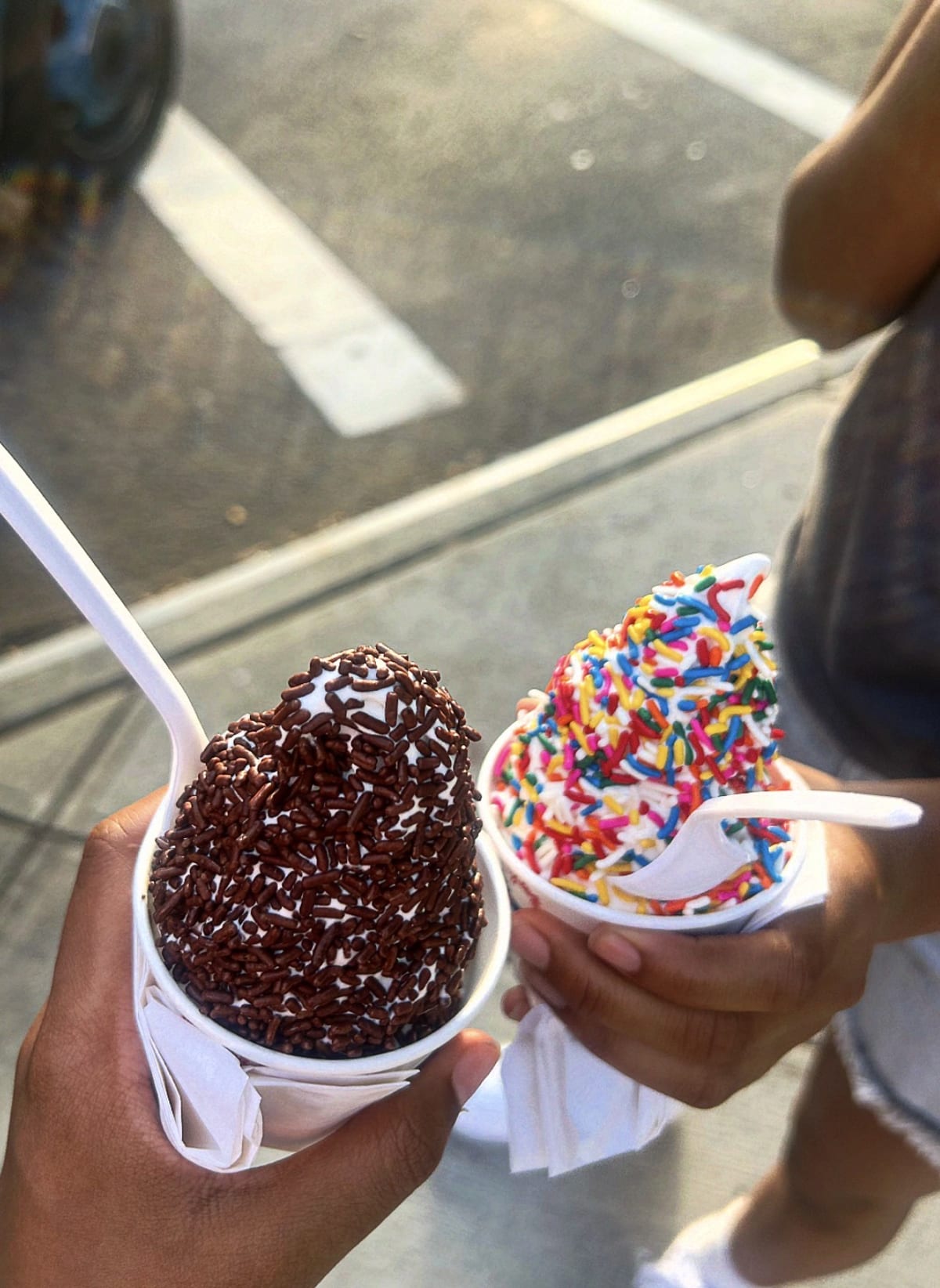 "Two girls holding their ice cream. '